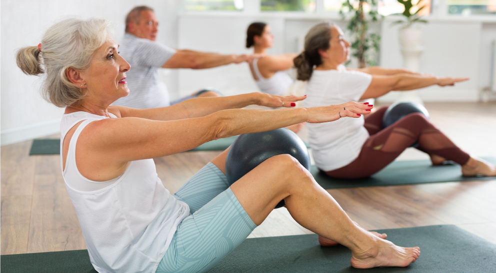 Seniors participate in a yoga class while exercising.