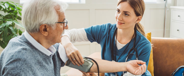 A woman assists a senior man at a senior living community.