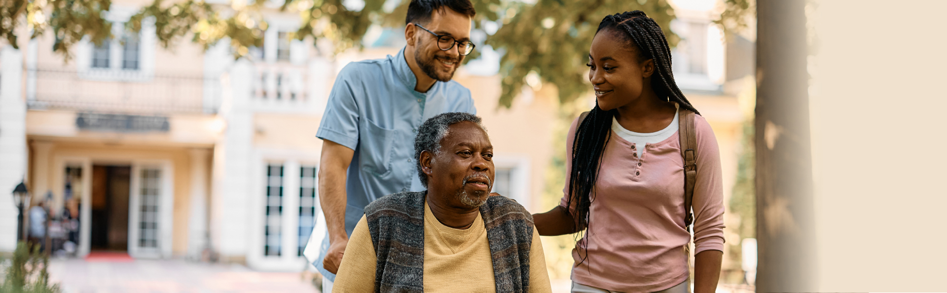 A picture of a senior man in a wheel chair with two others.