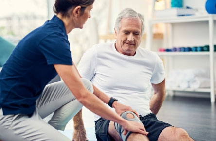 A senior man receives physical therapy.