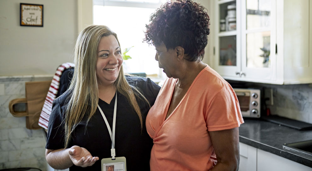 Caregiver smiling with arm around respite care resident | Presbyterian Village Athens